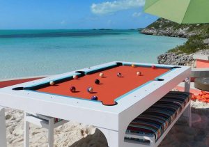 White Balcony outdoor pool table with all weather benches sits oceanfront in the Caribbean