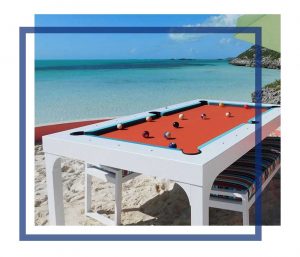 White Balcony outdoor pool table with all weather benches sits oceanfront in the Caribbean