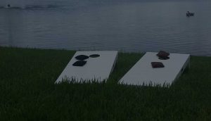 Outdoor cornhole game table set sits lakeside in client's Southwest Florida home