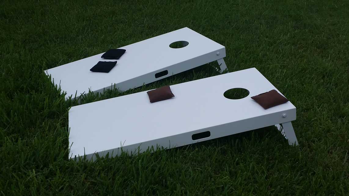 White, custom, outdoor cornhole set with black and brown beanbags