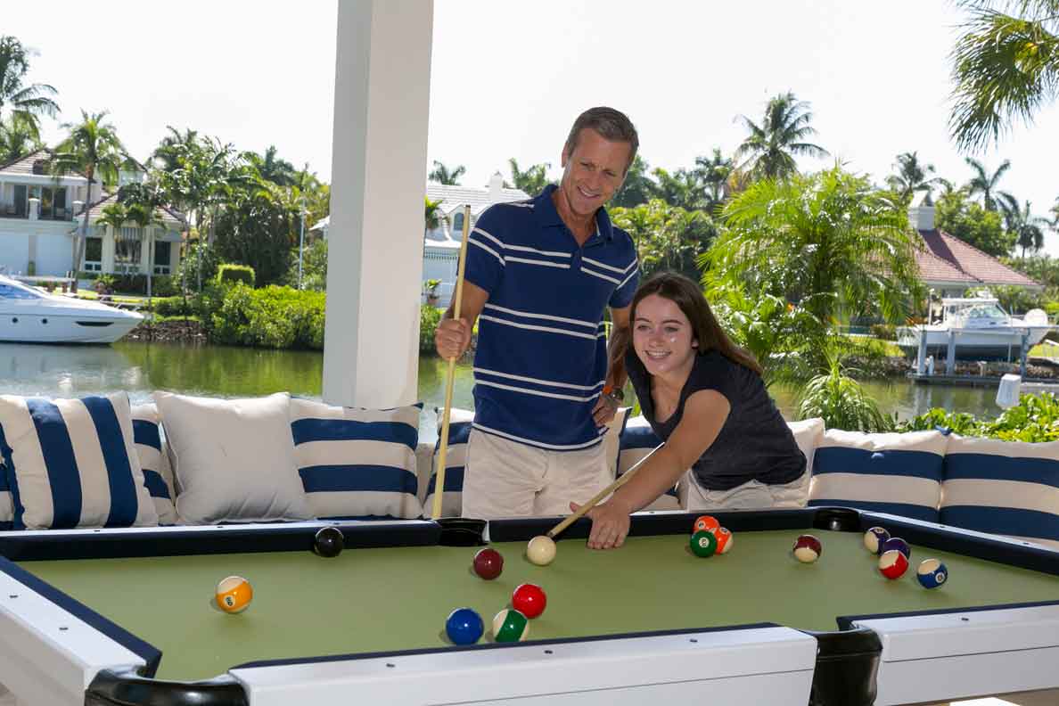 Father & daughter playing pool on an Oasis Outdoor Pool Table from R&R Outdoors, Inc.