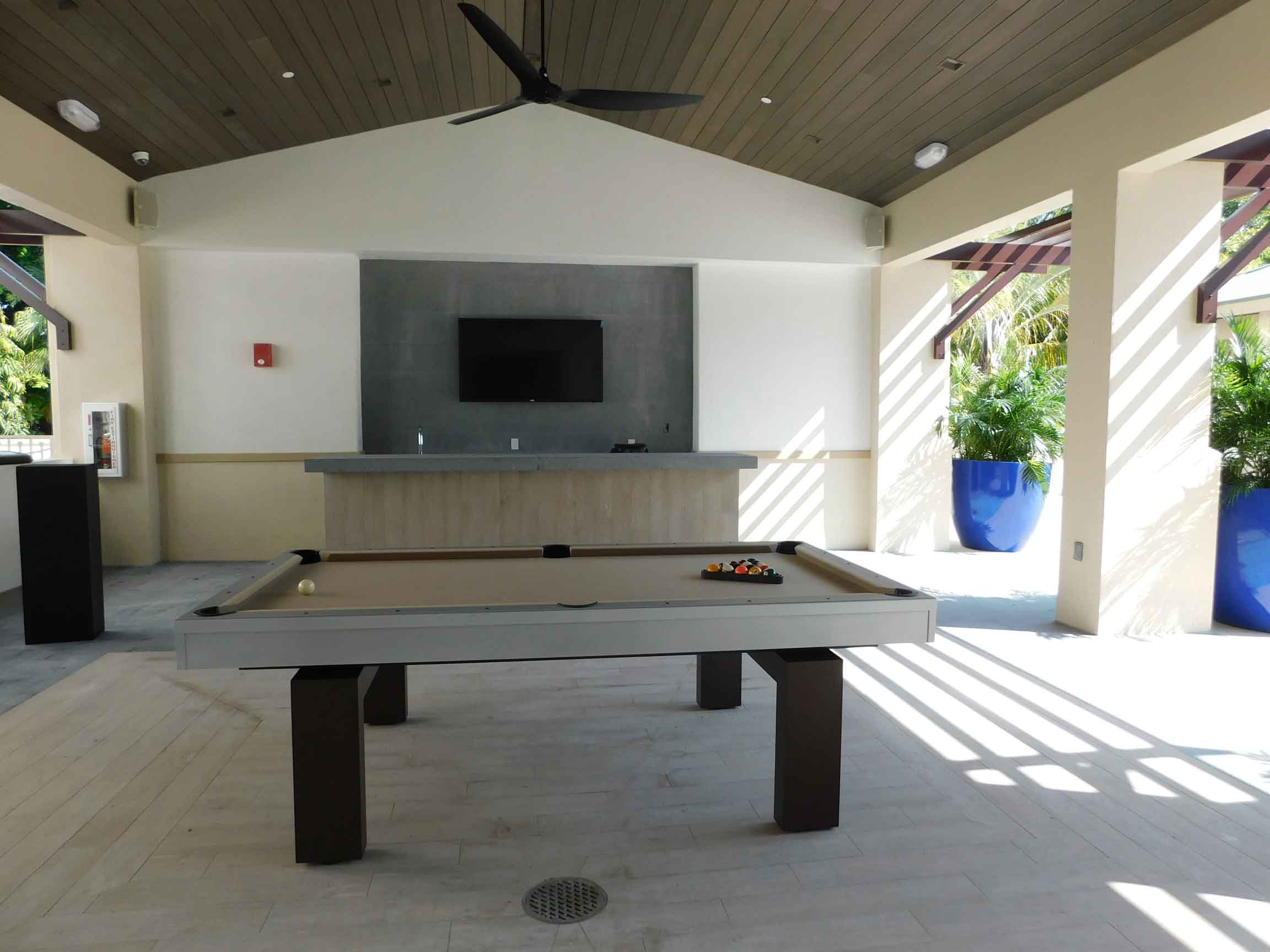 South Beach, custom outdoor pool table, is the focal point of client's outdoor living space in Florida