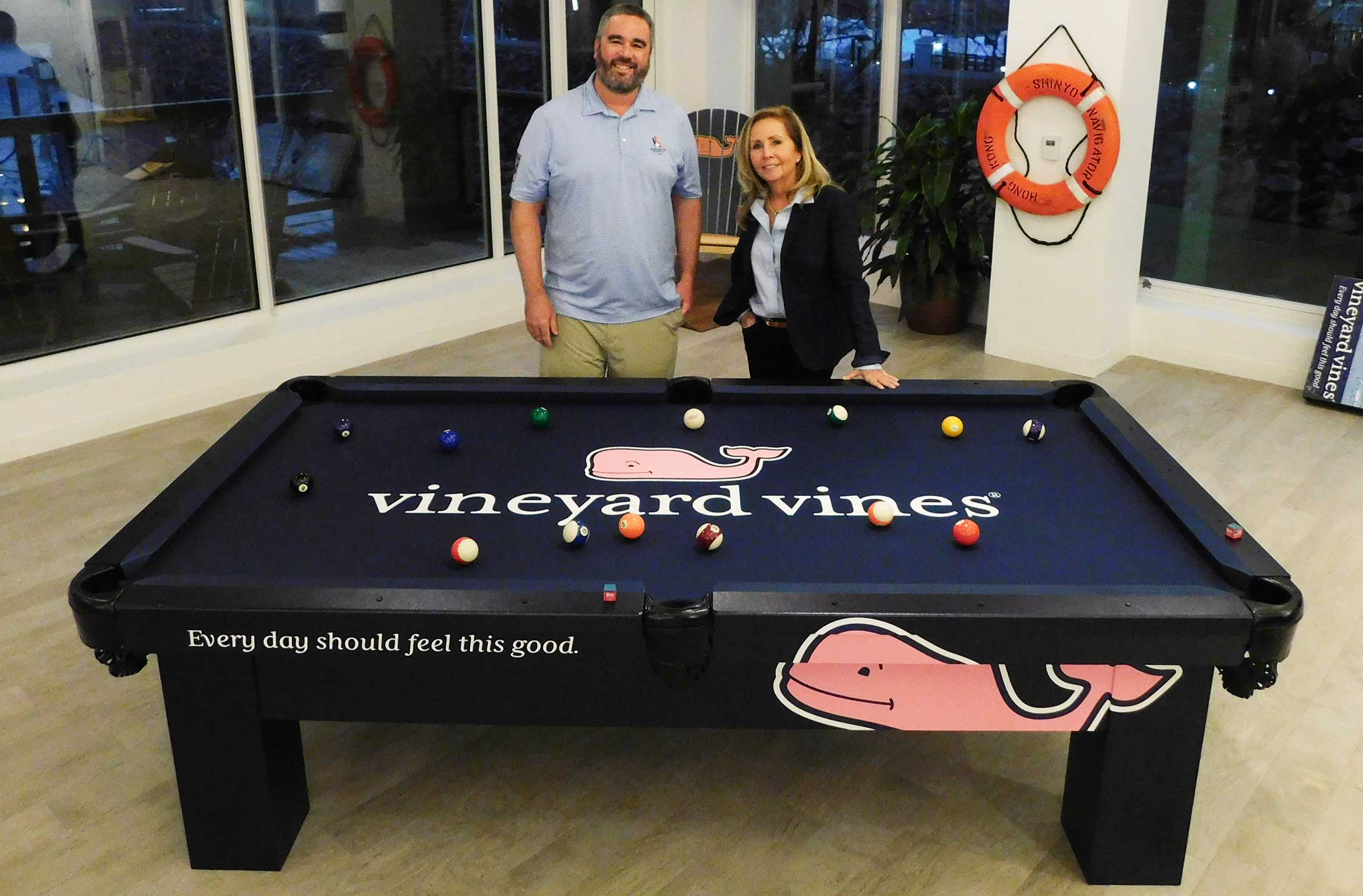 Robbie Selby and Shep Murray posing with Vineyard Vines customer Orion all weather pool table