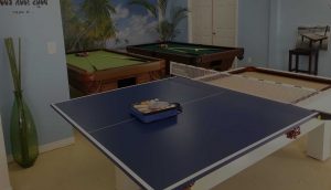 Assortment of outdoor pool tables and sample table tennis conversion top in R&R Outdoors All Weather Billiard showroom